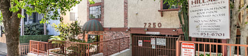 Gated entrance with property sign and landscaping at Joro Properties Apartments, Hollywood, CA