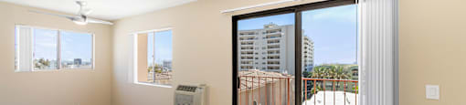 Empty room with balcony access and sliding glass door at Joro Properties Apartments, California
