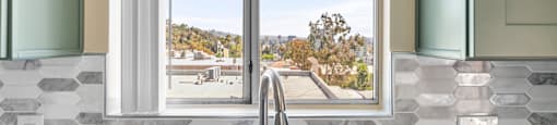 Kitchen window with hexagonal tile backsplash and modern faucet at Joro Properties Apartments, Hollywood, 90046
