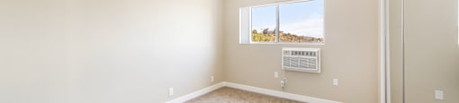 Empty carpeted bedroom with window air conditioning unit at Joro Properties Apartments, Hollywood