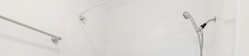 Clean shower with chrome fixtures and handheld sprayer at Joro Properties Apartments, Hollywood, CA
