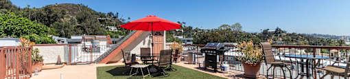 Rooftop terrace with artificial turf and outdoor grill at Joro Properties Apartments, California