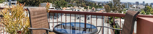 Private balcony with table chairs and hillside views at Joro Properties Apartments, California, 90046