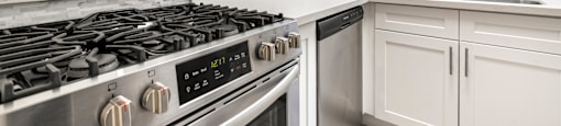 Modern kitchen with stainless steel appliances and white cabinetry at Joro Properties Apartments, Hollywood, CA 90046