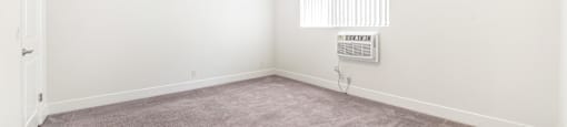 Empty carpeted room with ceiling fan and window at Joro Properties Apartments, Hollywood, CA