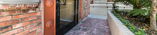 Gated entrance with intercom and striped awning at Joro Properties Apartments, California