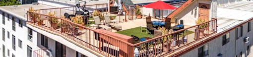 Rooftop terrace with seating and mountain backdrop at Joro Properties Apartments, California
