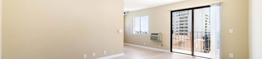 Spacious living room with sliding glass balcony door at Joro Properties Apartments, Hollywood, CA 90046