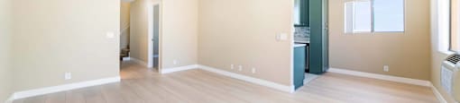 Open living room with kitchen and light wood floors at Joro Properties Apartments, Hollywood, CA