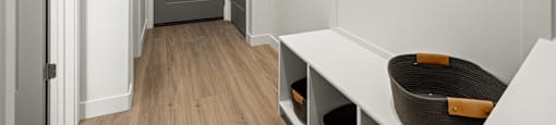 a hallway with white walls and a door and a hanging bag on the wall