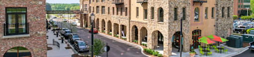 a city street with tall brick buildings and a bridge