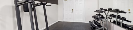 the fitness center with free weights and a mirror