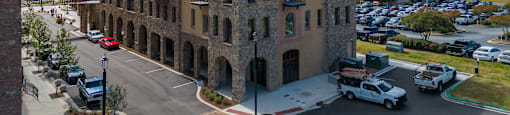 an aerial view of an old brick building in the middle of a parking lot