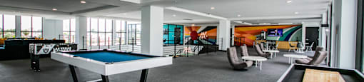 a game room with a pool table, foosball and shuffle board