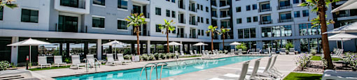 A large white building with a pool in front.