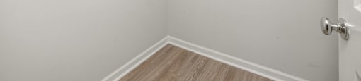 a room with white walls and a white closet with hanging racks at Ashford Townes Apartments, Fuquay-Varina