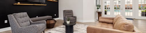 clubhouse with a brown couch, grey chair, and a TV