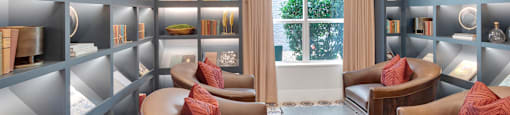 A well-lit, modern living room with a large window and a cozy seating area.
