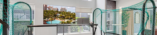 A trampoline room with a large window and a view of a cityscape.