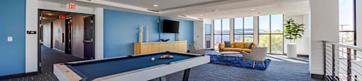 A pool table in a room with a view of the outside.
