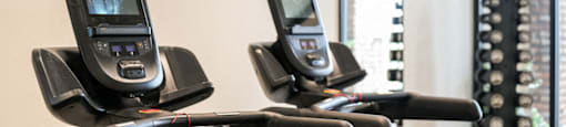a row of exercise bikes with cell phones on them in a gym