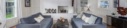 a living room with two couches in front of a fireplace  at Castilian Apartments, Orlando, FL