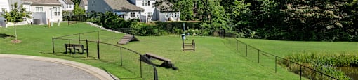 a park with a fenced in area and houses in the background at Ashford Townes Apartments, Apartments, Fuquay-Varina, NC