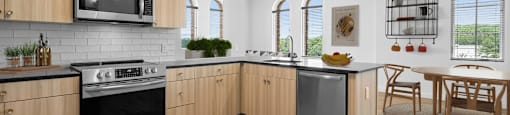 an open kitchen and dining area with wooden cabinets and stainless steel appliances