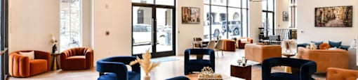 a lobby with couches chairs and tables and large windows