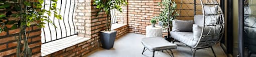 a balcony with a chair and a table and some plants
