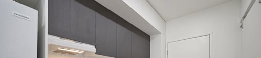 a kitchen with white cabinets and a refrigerator and a sink