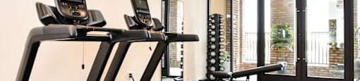 two treadmills in a gym with a ceiling fan