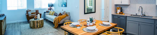 a living room and dining room with a table and chairs