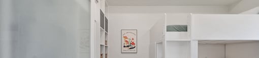 a small room with a bunk bed and a desk with a chair