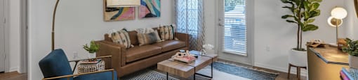 a living room with a brown couch and a blue chair