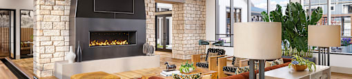 A modern living room with a brick fireplace and a pool table.