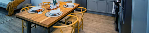 A modern kitchen with a dining table set for two.