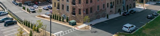 an aerial view of a brick building in a parking lot