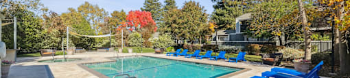 A pool surrounded by blue lounge chairs.