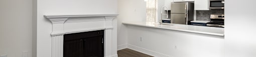 a living room with a fireplace and a kitchen