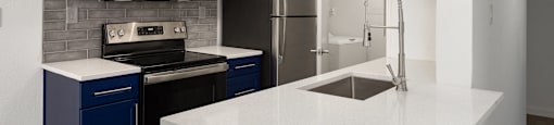 a white kitchen with blue cabinets and a white counter top