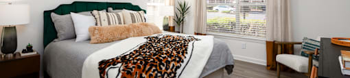 a bedroom with a bed with a leopard blanket