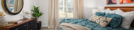 a bedroom with a bed and a dresser and a window