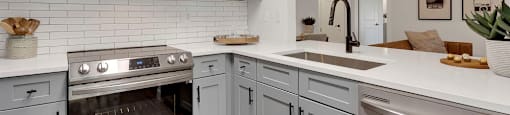 A modern kitchen with a stainless steel oven and microwave.