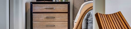 Close up of wood tone night stand, small plant, vase, and lamp through a  doorway at Bravada 193, Clearfield, 84015