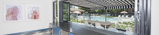 a kitchen with a counter and a window overlooking a pool