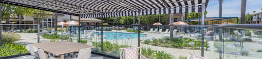 a patio with tables and chairs and a swimming pool