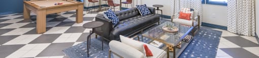 a living room with couches and a table with a pool table