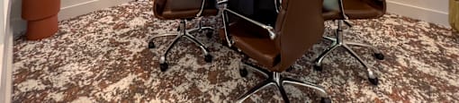 a conference room with a round table and chairs and a television