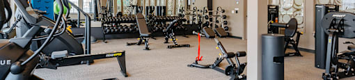 A gym with a variety of equipment including treadmills, weights, and exercise machines.
